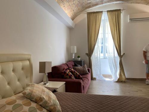 ローマにあるCampani Luxury Flatのベッドルーム1室(ベッド1台、ソファ、窓付)