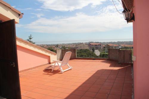 a white chair sitting on a terrace of a house at Gli Aranci Dell'Etna in Mascali