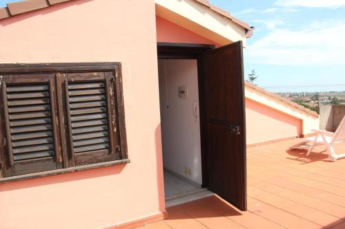 an open door of a house with a balcony at Gli Aranci Dell'Etna in Mascali