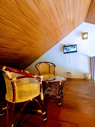 a room with two chairs and a table and a tv at Moon Plains Luxury Apartments in Nuwara Eliya