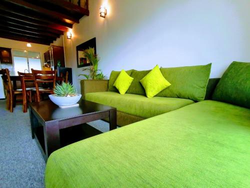 a living room with a green couch and a table at Moon Plains Luxury Apartments in Nuwara Eliya