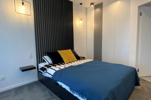 - une chambre avec un grand lit bleu et des oreillers jaunes dans l'établissement Apartament na Wodnej, à Łódź