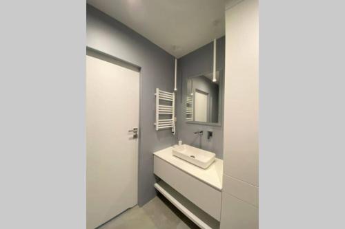 La salle de bains est pourvue d'un lavabo et d'un miroir. dans l'établissement Apartament na Wodnej, à Łódź