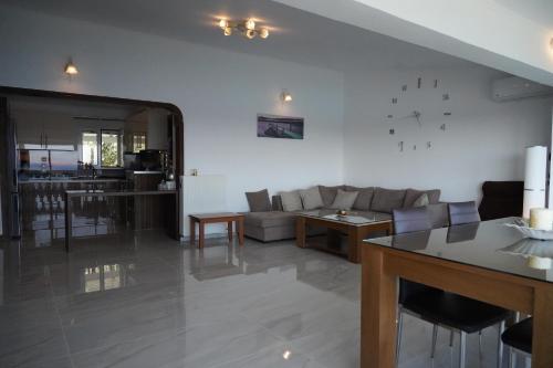 a living room with a couch and a clock on the wall at Valtos View in Parga