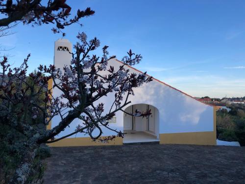 a white and yellow building with a clock tower at Quinta dos Girassóis FZ in Ferreira do Zêzere