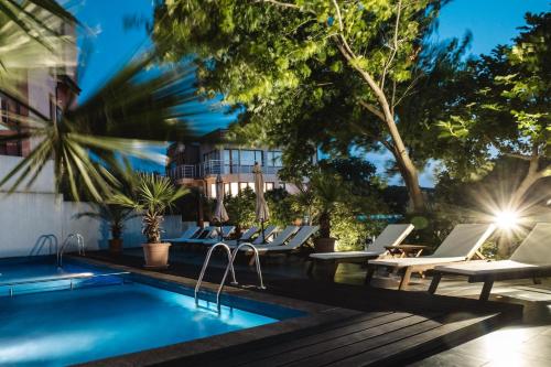 a swimming pool with lounge chairs next to a building at Design Hotel Logatero in Sozopol