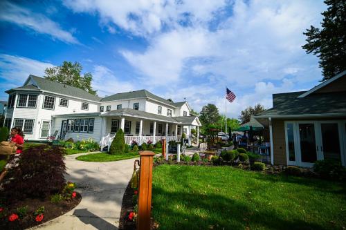 a white house with a flag in the yard at The Lakehouse Inn Geneva in Geneva-on-the-Lake