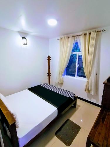 a bedroom with two beds and a window at Moon Plains Luxury Apartments in Nuwara Eliya