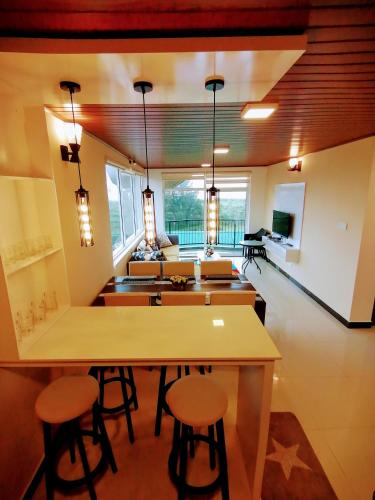 a kitchen with a table and stools in a room at Moon Plains Luxury Apartments in Nuwara Eliya