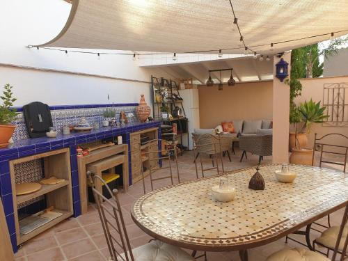 ein Wohnzimmer mit einem Tisch und einer Küche in der Unterkunft Premium Bed & Breakfast Casa Alegría Andaluza in Los Romanes