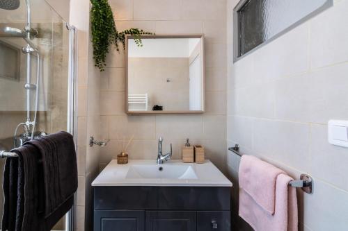 uma casa de banho com um lavatório e um espelho em Le Jardin Arlésien - Parking em Arles