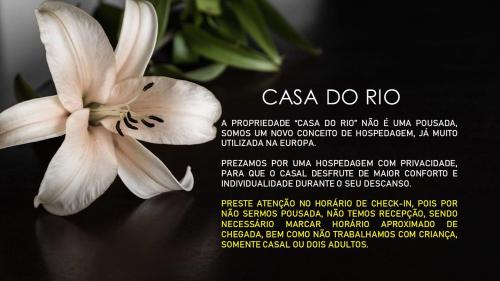 a white flower sitting on a table with a poem at Eco Chalés Águas Claras in Lumiar