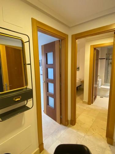 a room with a tv on a wall and a bathroom at MARINA LLANES IV in Llanes