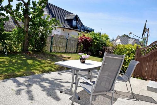 a white table and two chairs on a patio at Ferienhaus mit Terrasse am Heideweg in Baabe