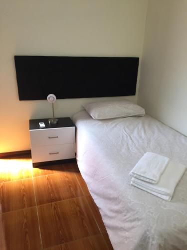 a bedroom with a white bed and a night stand at Casa Seixas Batista in Pinhão