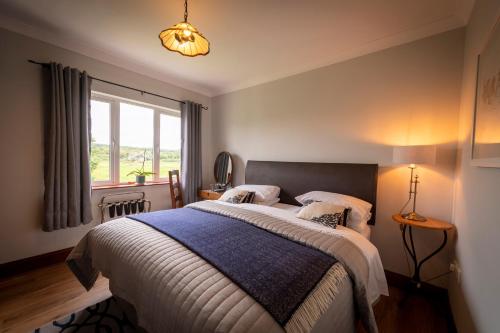 a bedroom with a large bed with a blue blanket at Bunratty Meadows Bed & Breakfast in Bunratty