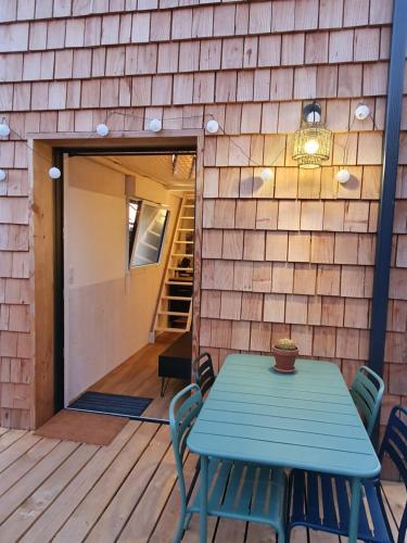 una mesa azul y sillas en una terraza de madera en TINY HOUSE Cosy 1 - Angers Green Lodge en Angers