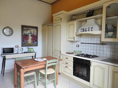 a kitchen with white cabinets and a wooden table at Il Gelso nella Valle in Agrigento