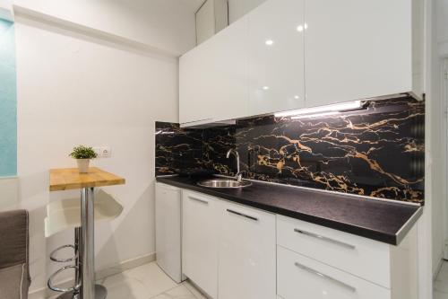 a kitchen with white cabinets and a black counter top at Del Soll in Polychrono
