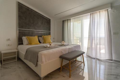 a bedroom with a large bed with yellow pillows and a chair at Del Soll in Polychrono