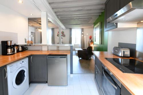 een keuken met een wasmachine en droger op een aanrecht bij The Lighthouse - Charming apartment - Beach and Town Center in Honfleur