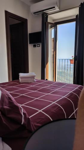 a bedroom with a purple bed with a view of the ocean at “Sa Scala” Bed&Terrace in Baunei