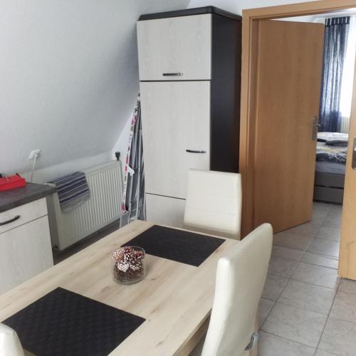 a kitchen with a wooden table and a refrigerator at FEWO BEI LEHMANNS in Werl