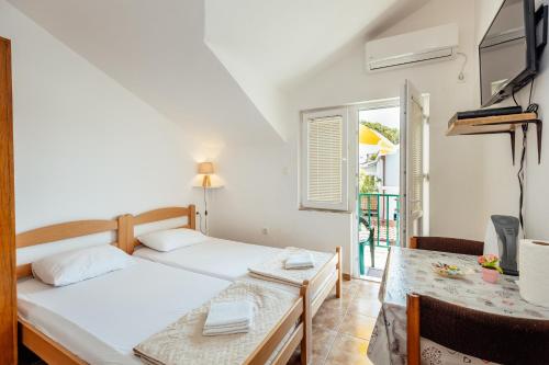 um quarto com uma cama, uma mesa e uma janela em Anastasija5 em Herceg-Novi