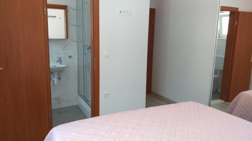 Schlafzimmer mit einem Bett, einer Dusche und einem Waschbecken in der Unterkunft APARTMAN KARLA in Lastovo