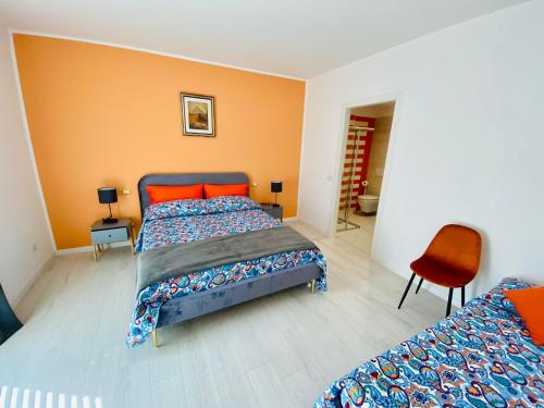 1 dormitorio con 2 camas y pared de color naranja en I Broletti del Garda en Pacengo di Lazise