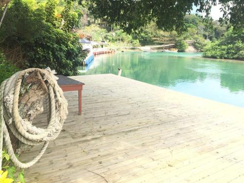 a wooden dock with a rope next to a river at Pousada Morada do Sol in Florianópolis