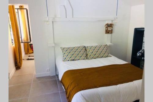a small bedroom with a bed in a room at L'annexe des Cigales, à l'ombre des chênes lièges in Capbreton