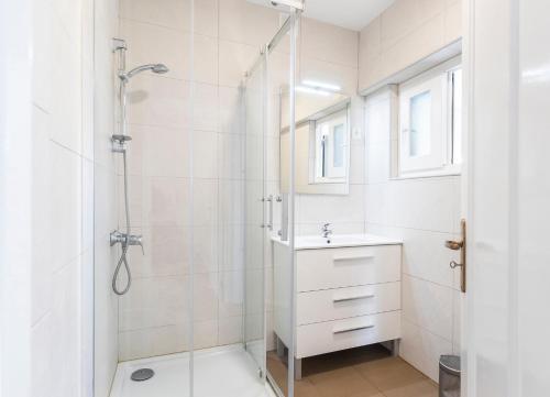 a white bathroom with a shower and a sink at PAREDE APARTMENT 2 in Cascais