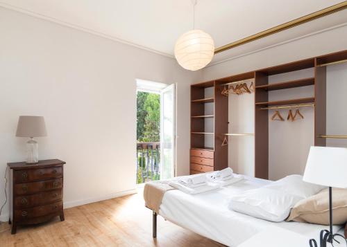 a white bedroom with a bed and a window at PAREDE APARTMENT 2 in Cascais