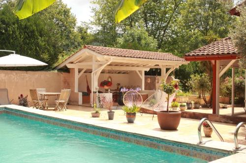 a pergola and a swimming pool next to a house at Kapera Maison d'Hotes in Macaye