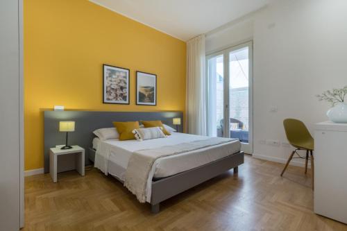 a bedroom with a bed and a yellow wall at Guesthouse Libeticus in Cagliari