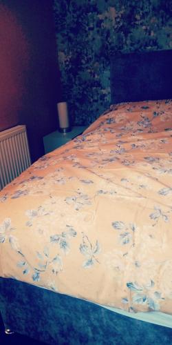 un letto con una coperta blu e bianca sopra di Cosy place a Derby