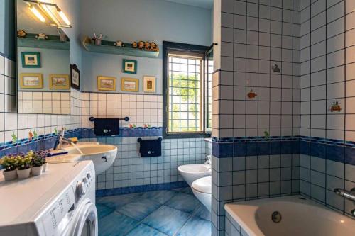 a blue and white bathroom with two sinks and two toilets at Sogno Mediterraneo Pula Sardegna villa a soli 300 mt dal mare in Porto Columbu - Perdʼe Sali