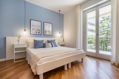 a bedroom with a bed with blue walls and a window at Guesthouse Libeticus in Cagliari