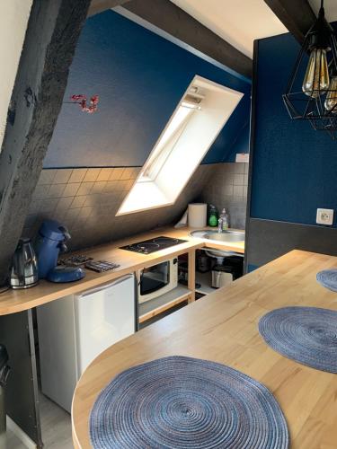 une cuisine avec une table en bois et une lumière. dans l'établissement Le bas-sablons, à Saint-Malo