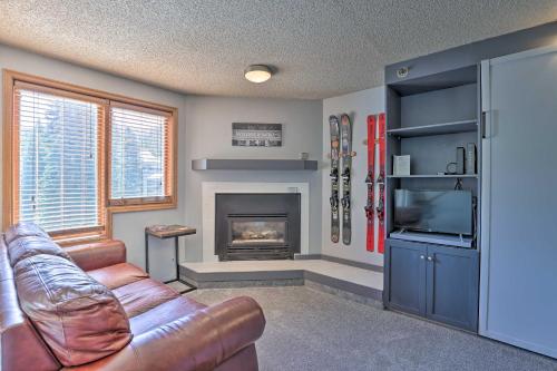 a living room with a couch and a fireplace at Cozy Ski-InandOut Winter Park Studio with Hot Tubs! in Winter Park