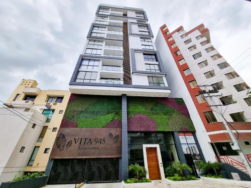a tall building with a green wall on it at Apartasuites VITA 945 RODADERO - By Bedviajes in Santa Marta