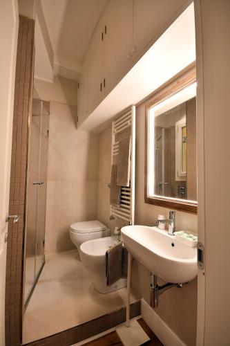 a bathroom with a sink and a toilet and a mirror at Smooth Mansion in Ponte Vecchio in Florence