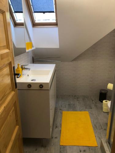 a small kitchen with a sink and a skylight at Dominik Apartmanház in Velence