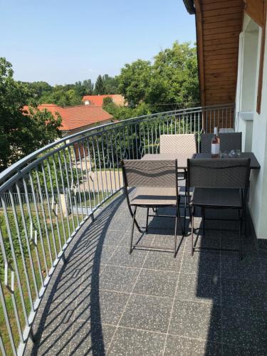 a patio with two chairs and a table on a balcony at Dominik Apartmanház in Velence