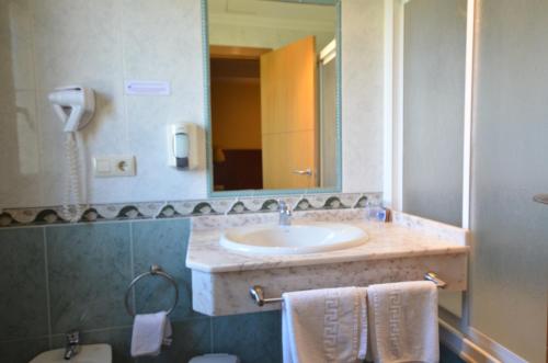 y baño con lavabo y espejo. en Hotel Maracaibo, en Portonovo