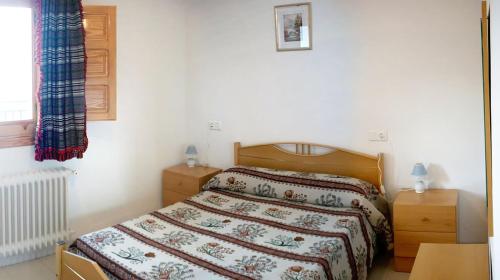 1 dormitorio con 1 cama, 2 mesitas de noche y ventana en CASASBLANCAS. Casa nr 5 en Alpujarra de la Sierra