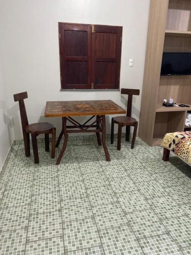 a table and two chairs in a room at Pousada Encantos da Amazônia in Alter do Chao