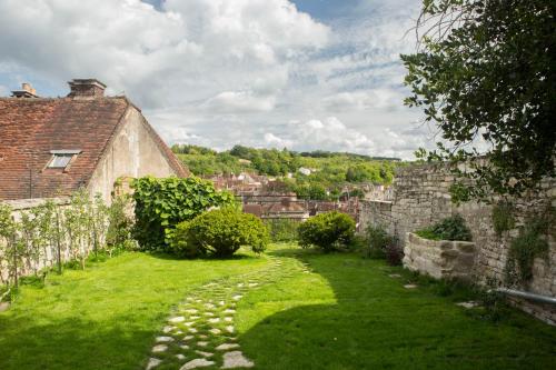 a garden with a stone path next to a building at La Maison du Haut in Tonnerre