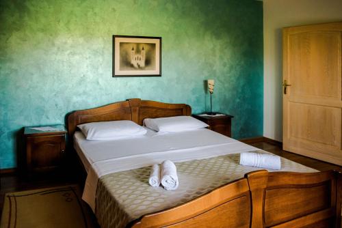 a bedroom with a bed with slippers on it at Villa Miriam Family Apartment in Međugorje